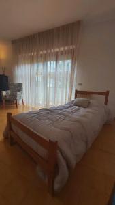 ein großes Bett in einem Schlafzimmer mit einem großen Fenster in der Unterkunft Alloggio Open Space. in Alba Adriatica