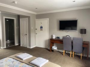 a bedroom with a desk and a television on the wall at Rooms at 31 in Stonehaven