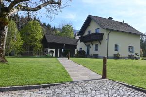 Biały dom z drzewem i ceglanym podjazdem w obiekcie Ferienhaus Humer w mieście Altmünster