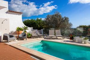 a swimming pool with chairs and a table next to a house at Quinta da Felicidade, Casa Estrela in Guia