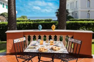 una mesa con comida y bebida en el balcón en Palazzo Moresco, en Santa Marinella