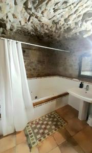 y baño con bañera y lavamanos. en Casa San Anton en Valderrobres