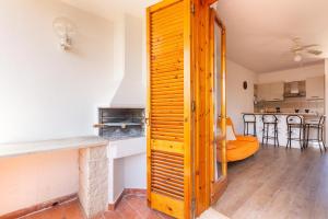 a kitchen with a wooden door leading into a living room at Casa di Gino` by BarbarHouse in San Foca +10 photos