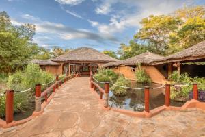 a resort with a bridge over a pond at Amboseli Sopa Lodge in Amboseli