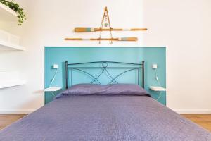 a bed with a blue headboard in a room at Casa di Gino` by BarbarHouse in San Foca
