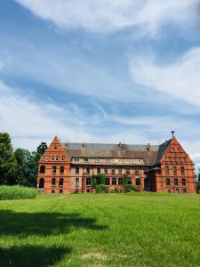 un gran edificio de ladrillo en un campo de hierba en Ferienwohnung Adelheid 