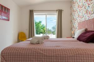 a bedroom with two towels on a bed with a window at Quinta da Felicidade, Casa Estrela in Guia +29 photos