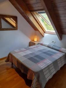 1 dormitorio con 1 cama en una habitación con ventana en Apartamento abuhardillado con velux erta 3 en Pla de l'Ermita
