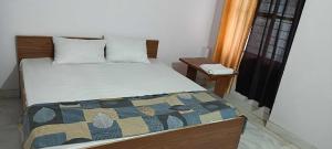 a bedroom with a bed with a quilt on it at OYO Jsb Royal Inn in Muzaffarnagar