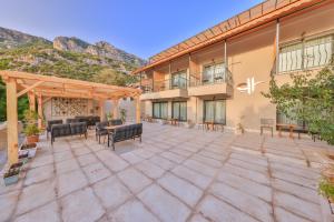 an outdoor patio of a building with chairs and tables at Cinar Butik Hotel in Kas