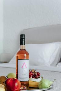 a bottle of apple cider next to a plate of fruit at Apollo Resort in Agia Marina Aegina