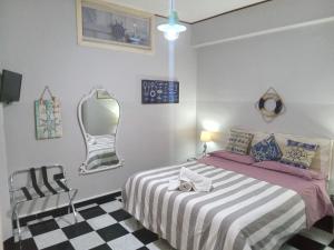 1 dormitorio con cama, espejo y silla en Salvone's house B&B, en Giardini Naxos