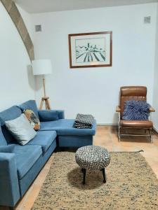 sala de estar con sofá azul y silla en Casa San Anton en Valderrobres