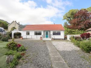 a white house with a red roof and a driveway at Haddef Penmaenmawr in Penmaen-mawr