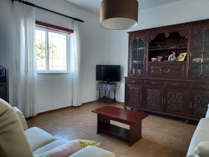 una sala de estar con un gran armario de madera y una mesa. en Casa Férias, 