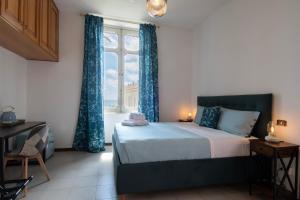 1 dormitorio con 1 cama con cortinas azules y ventana en Palazzo Moresco, en Santa Marinella