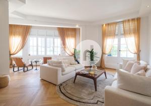 a living room with two white couches and a table at hovoh homes Bugis Rochor in Singapore