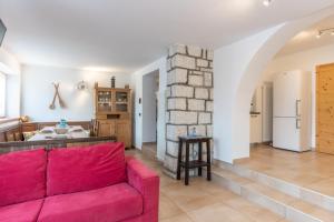 uma sala de estar com um sofá vermelho e uma cozinha em Casa al Lez, Cavareno Ospitar em Cavareno