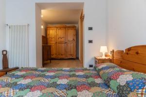 um quarto com uma cama com uma colcha colorida em Casa al Lez, Cavareno Ospitar em Cavareno