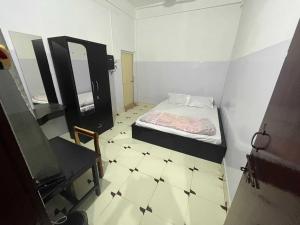 a small bedroom with a bed and a tiled floor at SPOT ON Hotel Mist in Dimāpur