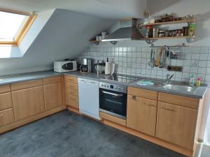 uma cozinha com um fogão branco e um lavatório em Ferienwohnung Bussard em Patersberg