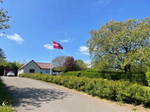 a canadian flag flying over a road next to a house at Cozy Garden Glamping in Svendborg