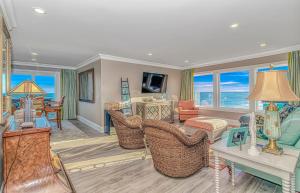 a living room with wicker chairs and a room with the ocean at Sea Something Beautiful in Myrtle Beach