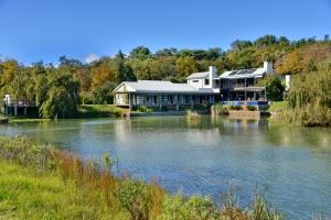 a large house sitting on top of a river at Ladybird Lodge in Stellenbosch
