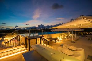 una terrazza con tavoli, sedie e piscina di OceanStone 1-BR next building view a Bang Tao Beach