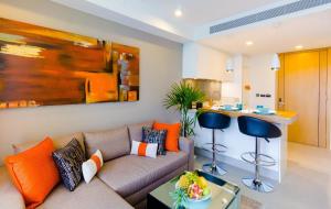 - un salon avec un canapé et des oreillers orange dans l'établissement OceanStone 1-BR next building view, à Bang Tao Beach