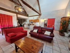 a living room with a red couch and a table at Gîte Donnery, 4 pièces, 6 personnes - FR-1-590-23 in Donnery
