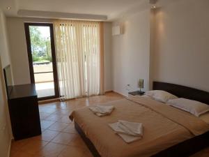 a bedroom with a large bed with two towels on it at Golden Dunes Primorsko Apartments in Primorsko +139 photos