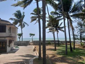 a group of palm trees next to a building at Vaishali Beach Villa in Suratakal