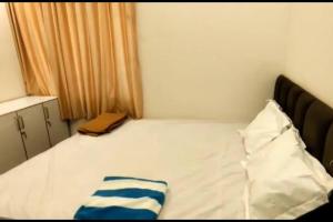 ein kleines Schlafzimmer mit einem weißen Bett mit blauen Streifen in der Unterkunft Vaishali Beach Villa in Suratakal