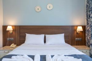 a bedroom with a bed with white towels on it at Bronze Hotel in Oludeniz