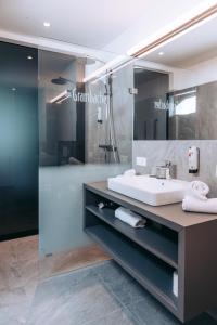 a bathroom with a sink and a shower at Hotel Das Grambacher 