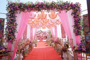 een gangpad op een bruiloft met roze en paarse bloemen bij 5 States Resort in Amritsar