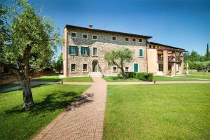 ein großes Steingebäude mit einem Backsteinweg im Hof in der Unterkunft Luxuryloft La Guarnigione in Valeggio sul Mincio