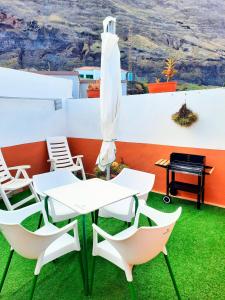 a table and chairs and an umbrella on a patio at Vivienda vacacional Casa Rosi in Frontera