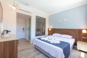 um quarto de hotel com uma cama grande e uma casa de banho em Bronze Hotel em Oludeniz