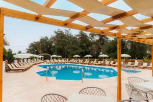 a pool with chairs and umbrellas at a resort at Oula Maisonettes Suites in Kavos