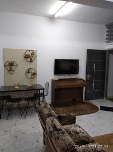 a living room with a couch and a flat screen tv at بيت ضيافة حنضلة in Bethlehem