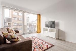 sala de estar con sofá y TV en Center of Antwerp, Fully Equipped, Train Station en Amberes