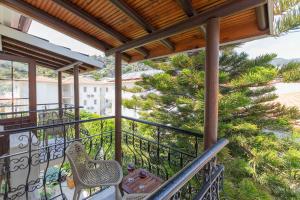 a balcony with two chairs and a tree at Bronze Hotel in Oludeniz