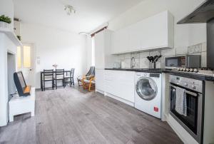 a kitchen with a washer and dryer in it at Bright Spacious Maida Vale Flat 5 - minutes from Station in London