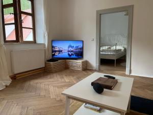 a living room with a flat screen tv and a table at LIBORIA II Wohnen im Denkmal Augsburgs in Augsburg
