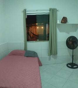um quarto com uma cama rosa e uma janela em RecantoNeryCoroavermelha-temporada em Coroa Vermelha