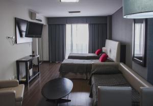 a hotel room with two beds and a couch at Recoleta Plaza by Ayres in Buenos Aires