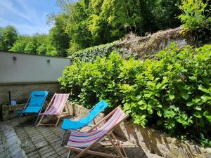 three chairs sitting on a patio next to a hedge at Maison face à l'abbaye d'Hautvillers - 2 bedrooms 2 Bathrooms, parking in Hautvillers