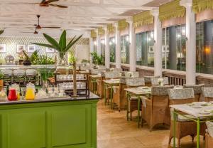 a restaurant with green counters and tables and chairs at Fairmont The Norfolk in Nairobi
